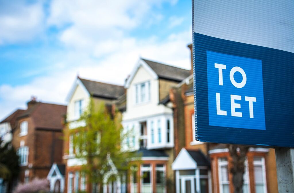 Street view of some houses with a 'to let' sign in the foreground.