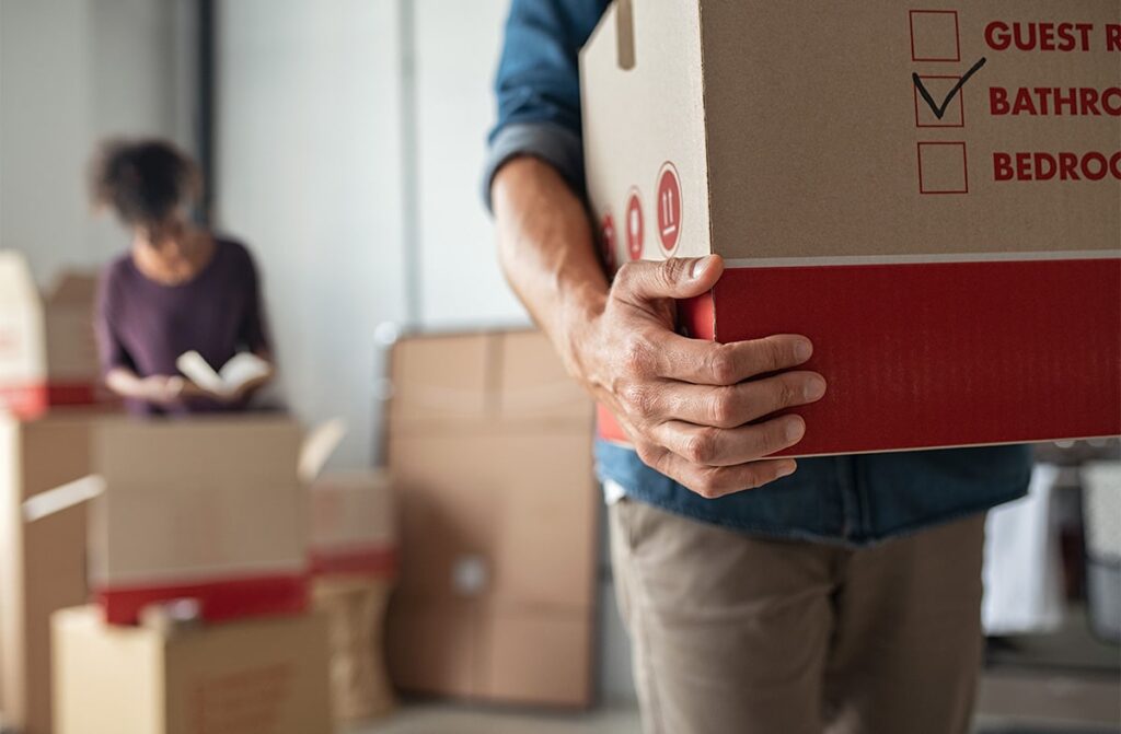 Man moving boxes around for moving house.